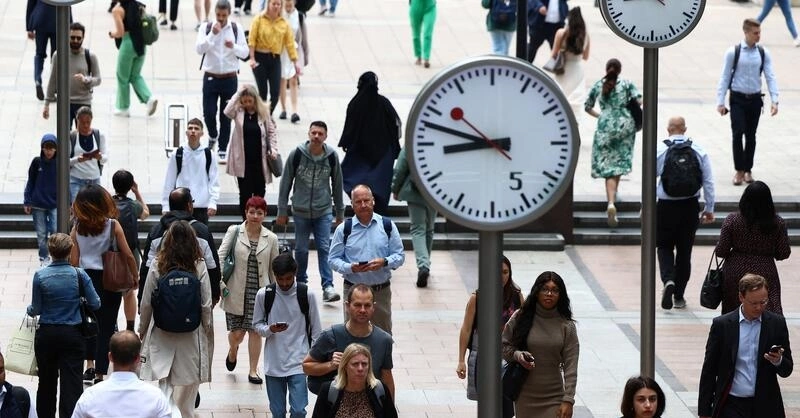 Người đi bộ qua khu tài chính Canary Wharf ở London, Anh, tháng 8/2023. Ảnh: Reuters